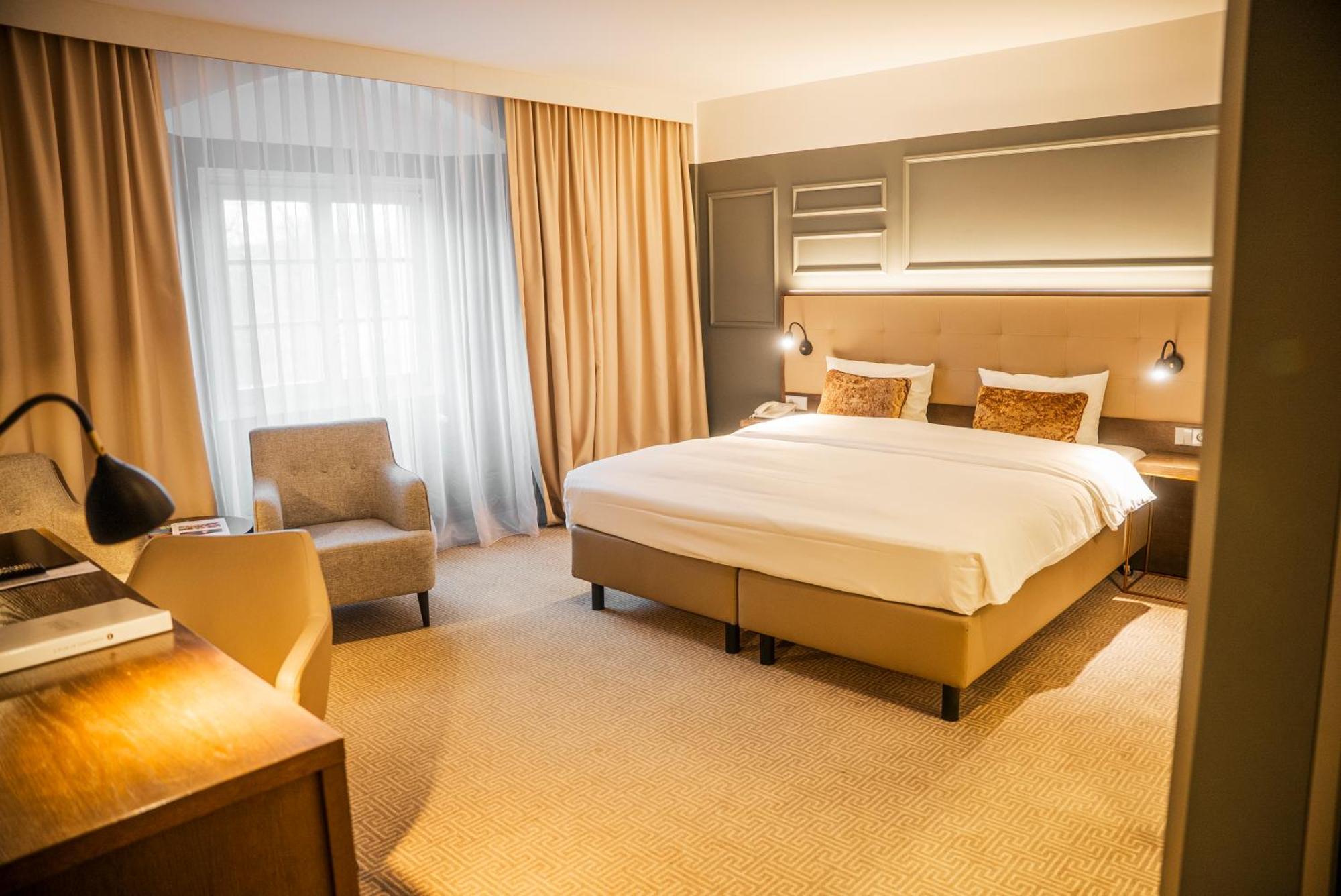 Zimmer mit Kingsize-Bett und Gartenblick.